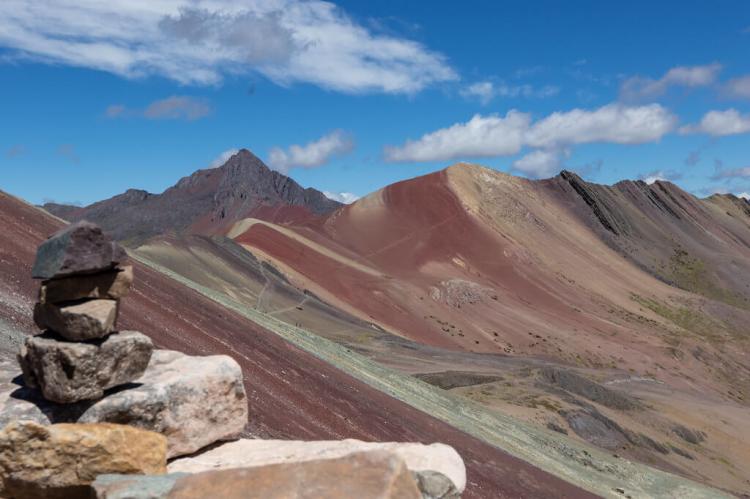 Cairn atop Vinicunca with Jatunrritioc mountain in the background, Vilcanota mountain range, Peru